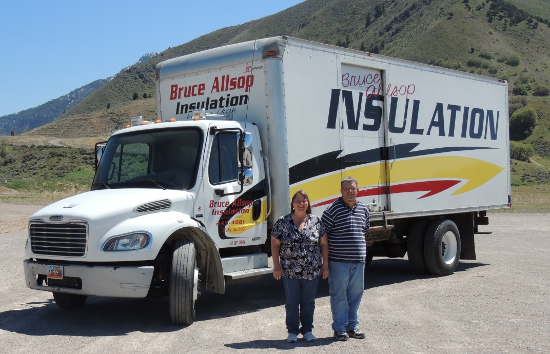 Dennis and Kim Allsop posing in front of one of the insulation installation trucks